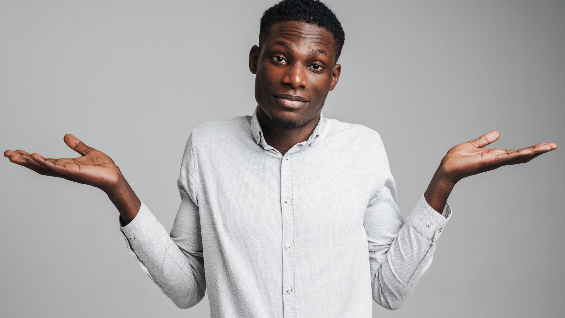 A man shrugging with his palms turned up, unsure whether his symptoms could be an STI